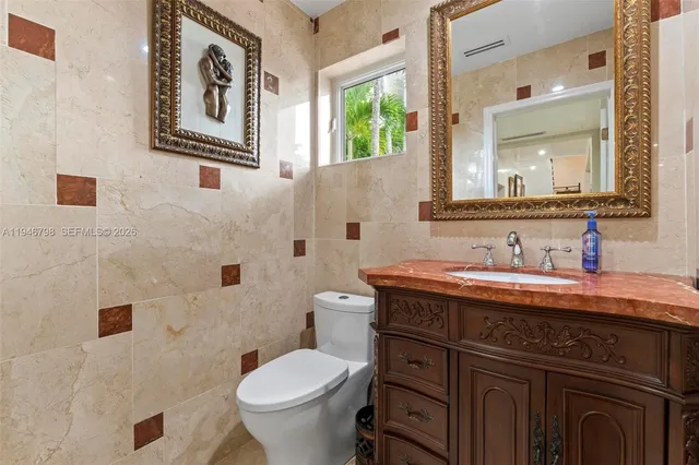 a kitchen with stainless steel appliances granite countertop a sink a stove and a dining table with wooden floor