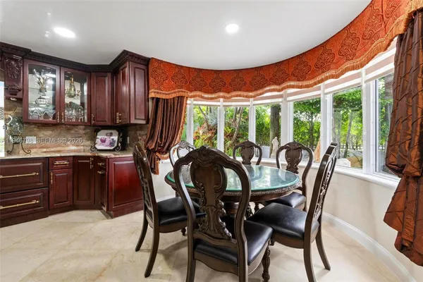 a dining room with furniture a flat screen tv and a floor to ceiling window