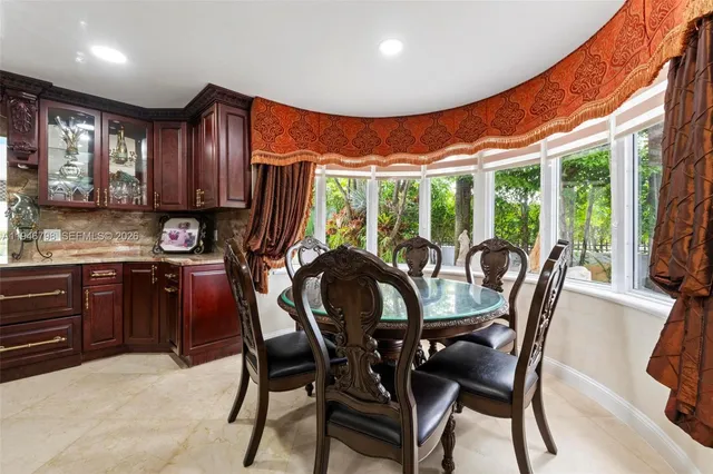 a dining room with furniture a flat screen tv and a floor to ceiling window