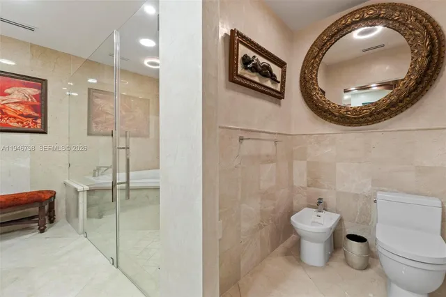 a bedroom with a bed a mirror and a large window