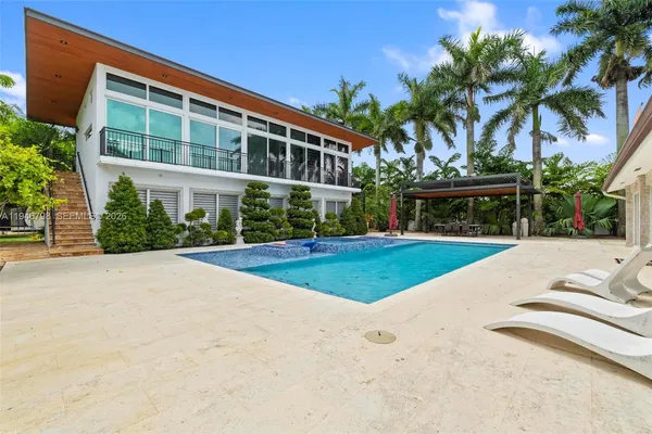 a kitchen with stainless steel appliances a refrigerator a stove a microwave a dining table and chairs