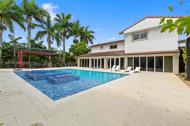 a view of a kitchen with kitchen island a large window a sink and stainless steel appliances