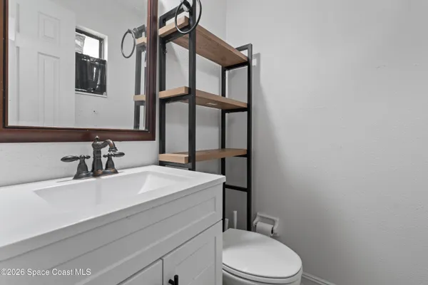 a bathroom with a sink a toilet and mirror