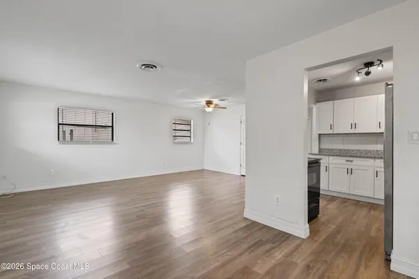 a view of a kitchen with wooden floor and a sink