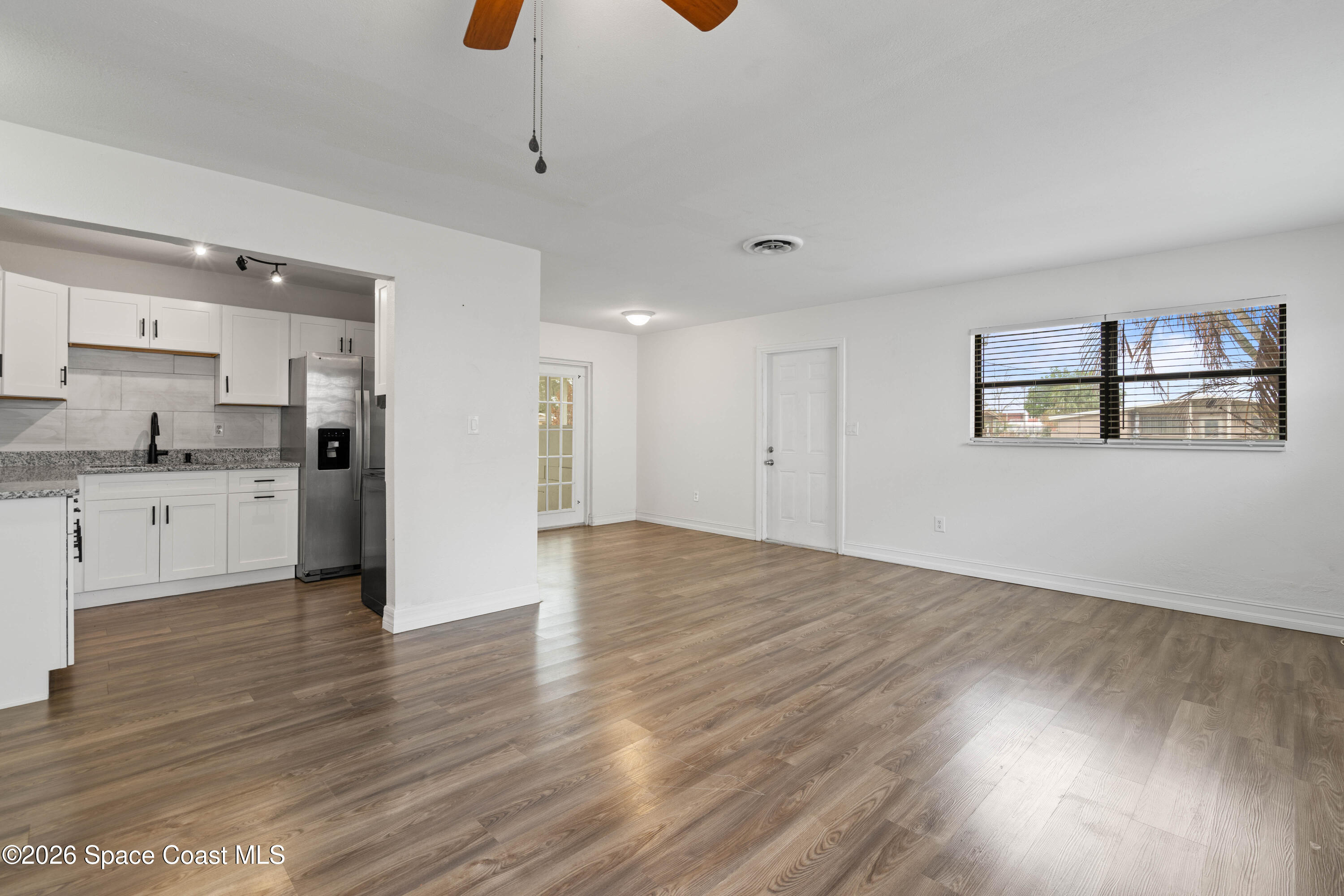 4037 Edwards Street Melbourne, FL 32901 - Photo 7 of 20 a view of kitchen and empty room with wooden floor