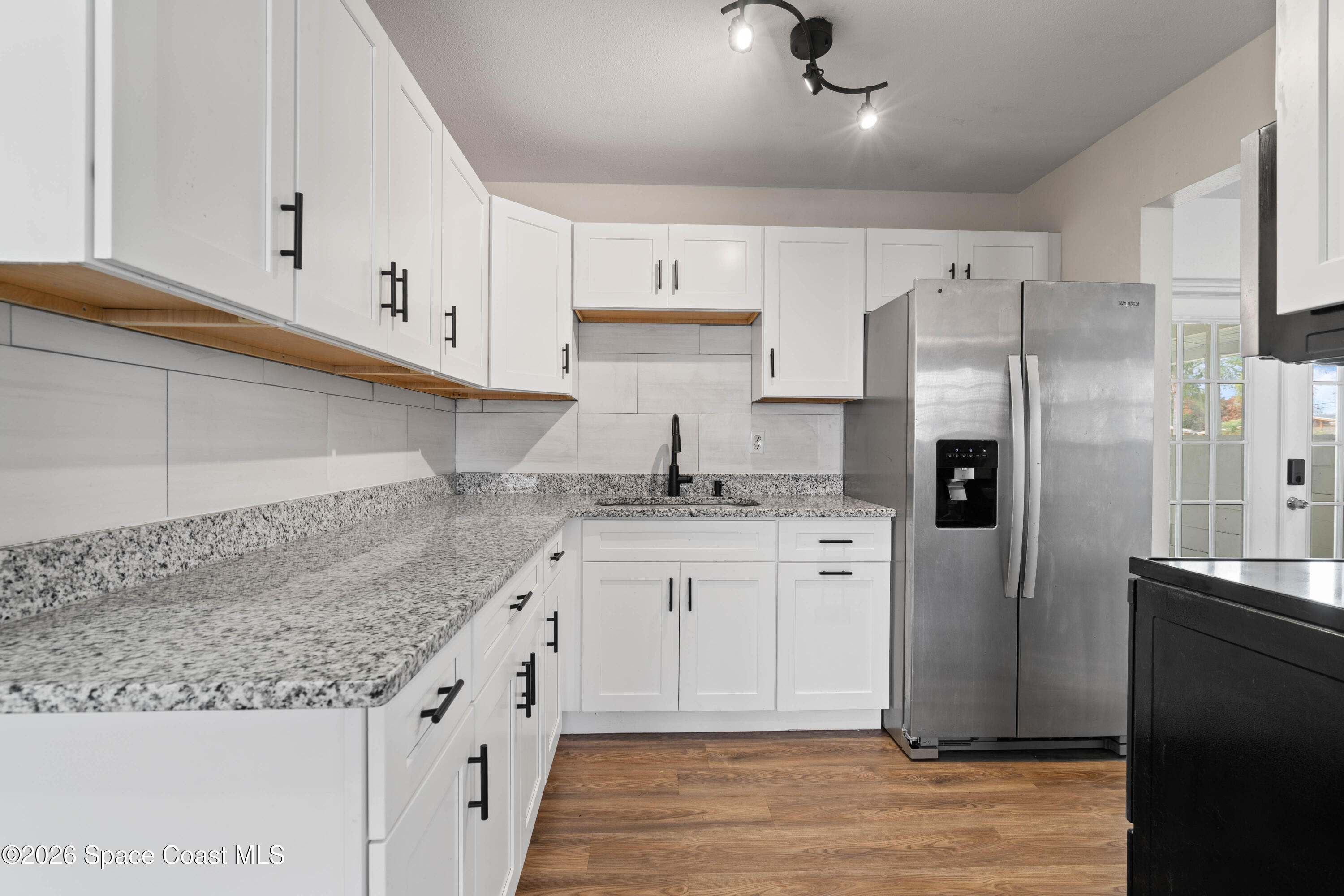 4037 Edwards Street Melbourne, FL 32901 - Photo 8 of 20 a kitchen with granite countertop a sink stainless steel appliances and cabinets