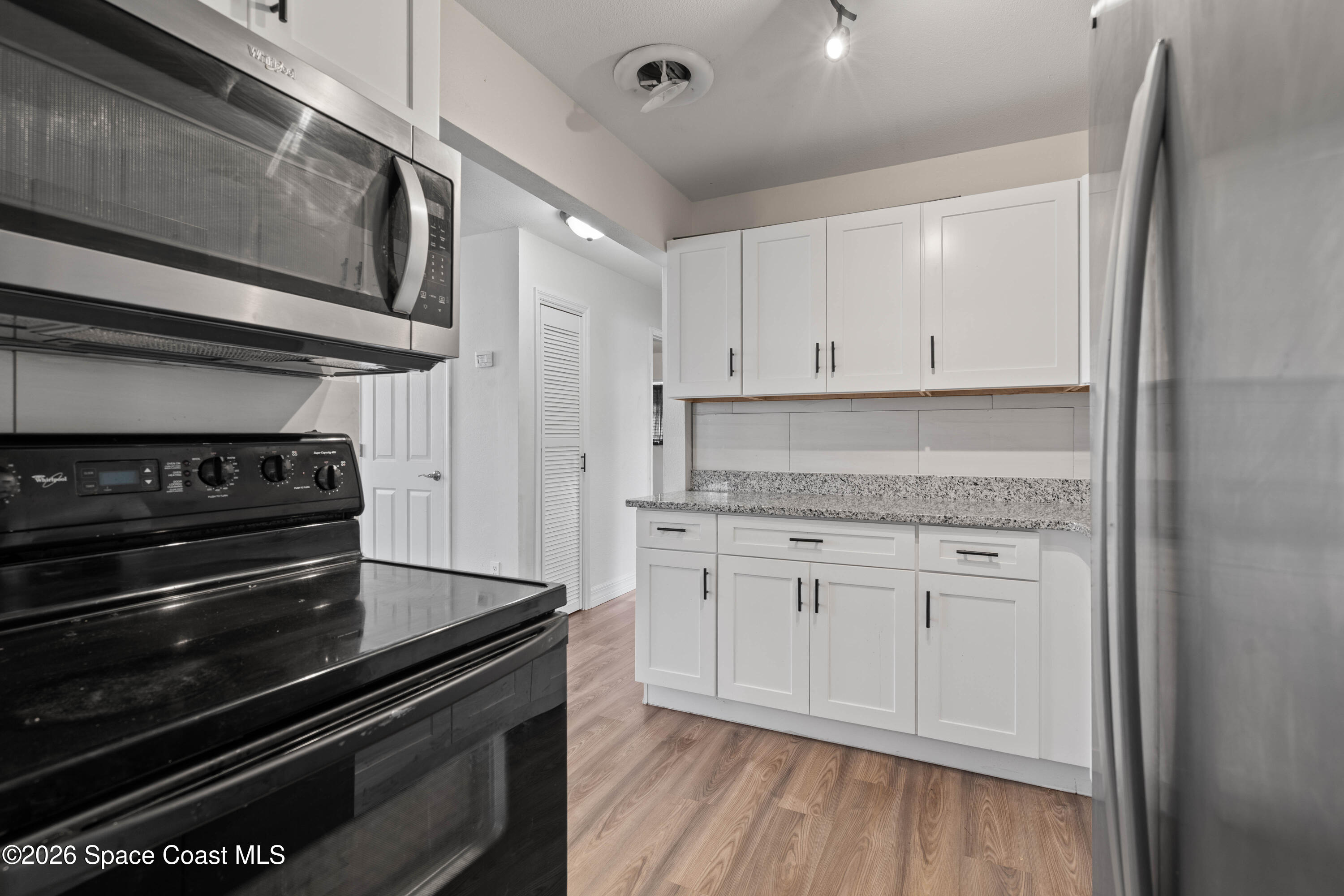4037 Edwards Street Melbourne, FL 32901 - Photo 10 of 20 a kitchen with white cabinets and appliances