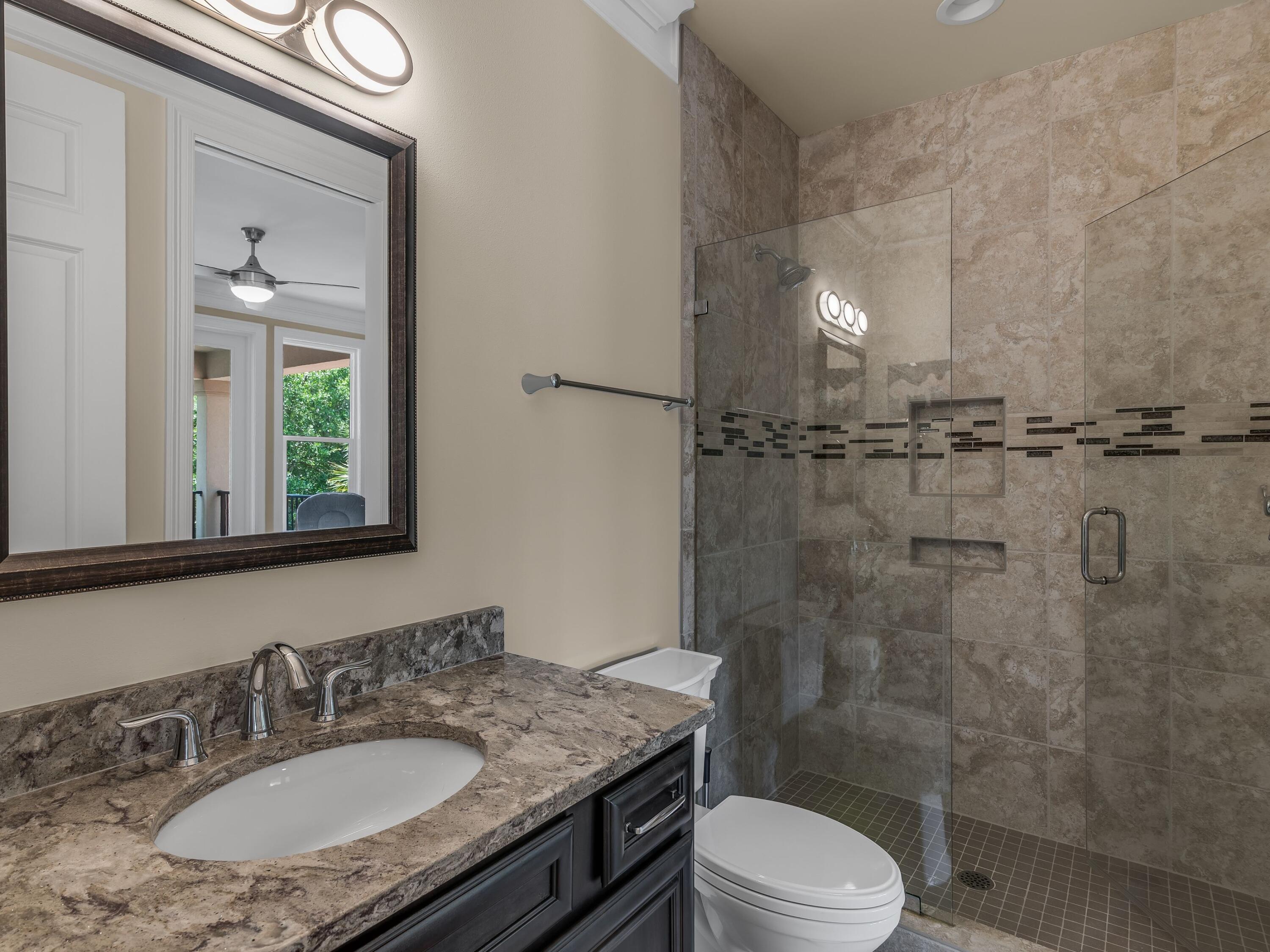 2916 Pine Valley Drive Sandestin, FL 32550 - Photo 37 of 48 a bathroom with a granite countertop sink toilet a mirror and shower