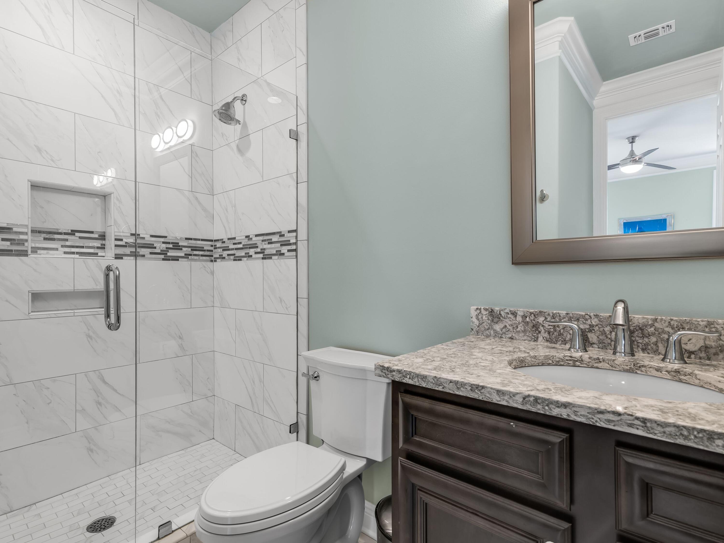 2916 Pine Valley Drive Sandestin, FL 32550 - Photo 39 of 48 a bathroom with a granite countertop sink a toilet a mirror and shower