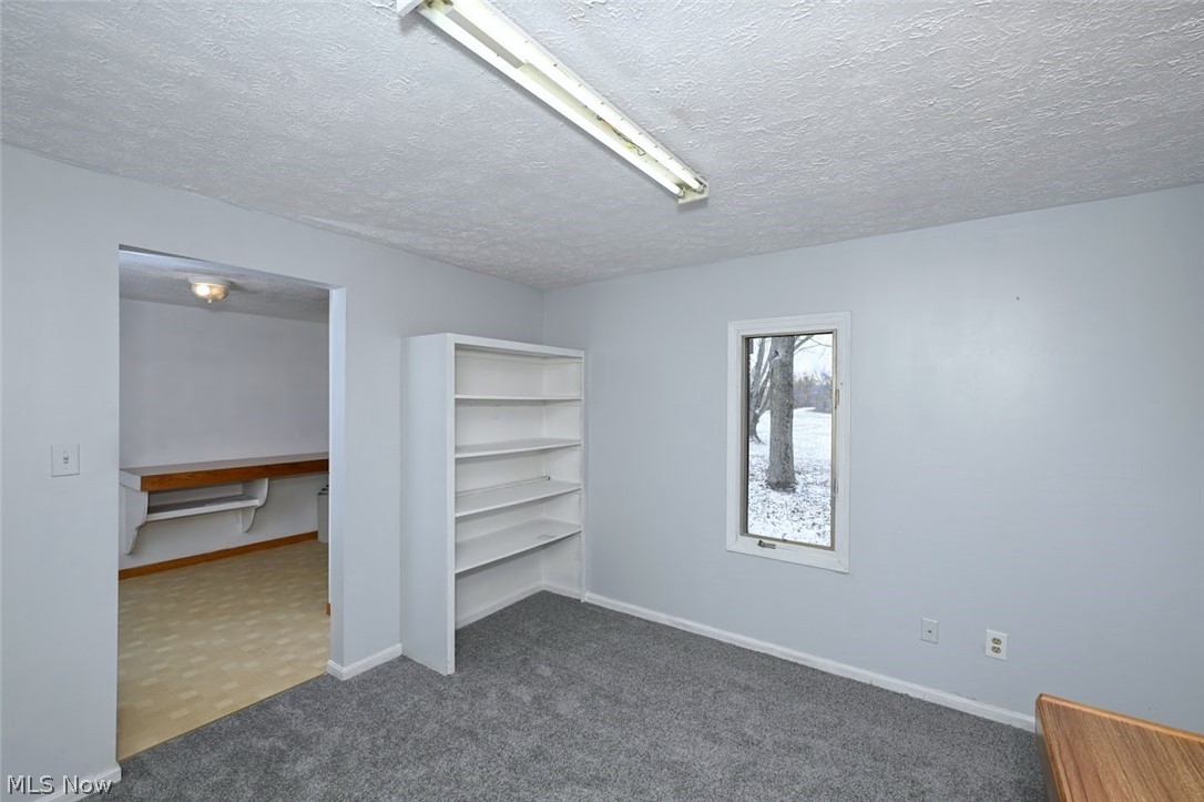 6151 Taylor Road Clinton, OH 44216 - Photo 27 of 49 *FIRST FLOOR OFFICE W/BRAND NEW CARPET, BUILT IN SHELVING AND ALSO BUILT IN DESK ON THE OTHER SIDE. THE LAUNDRY RM AND THIS OFFICE WERE AN ADDITION YEARS AGO. ALSO COULD BE USED AS A (5TH) FIRST FLOOR BEDROOM IF WANTED! ~