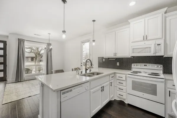 a kitchen with white cabinets and white appliances