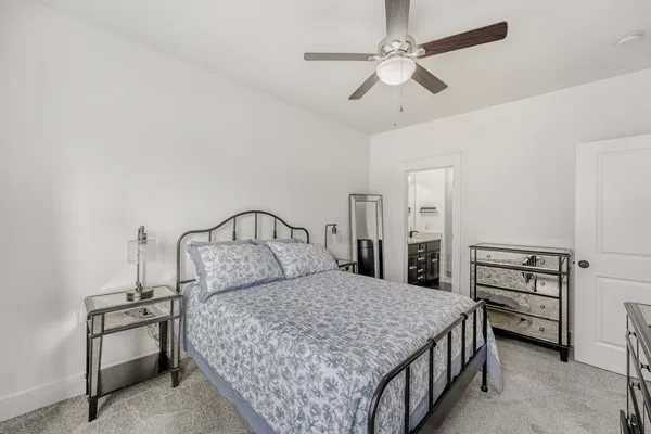 a bedroom with a bed a chandelier and a window