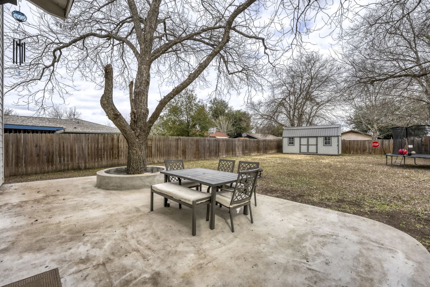 125 Irene Street Elgin, TX 78621 - Photo 19 of 24 Fenced backyard with outdoor dining space, a patio, a storage shed, and a trampoline
