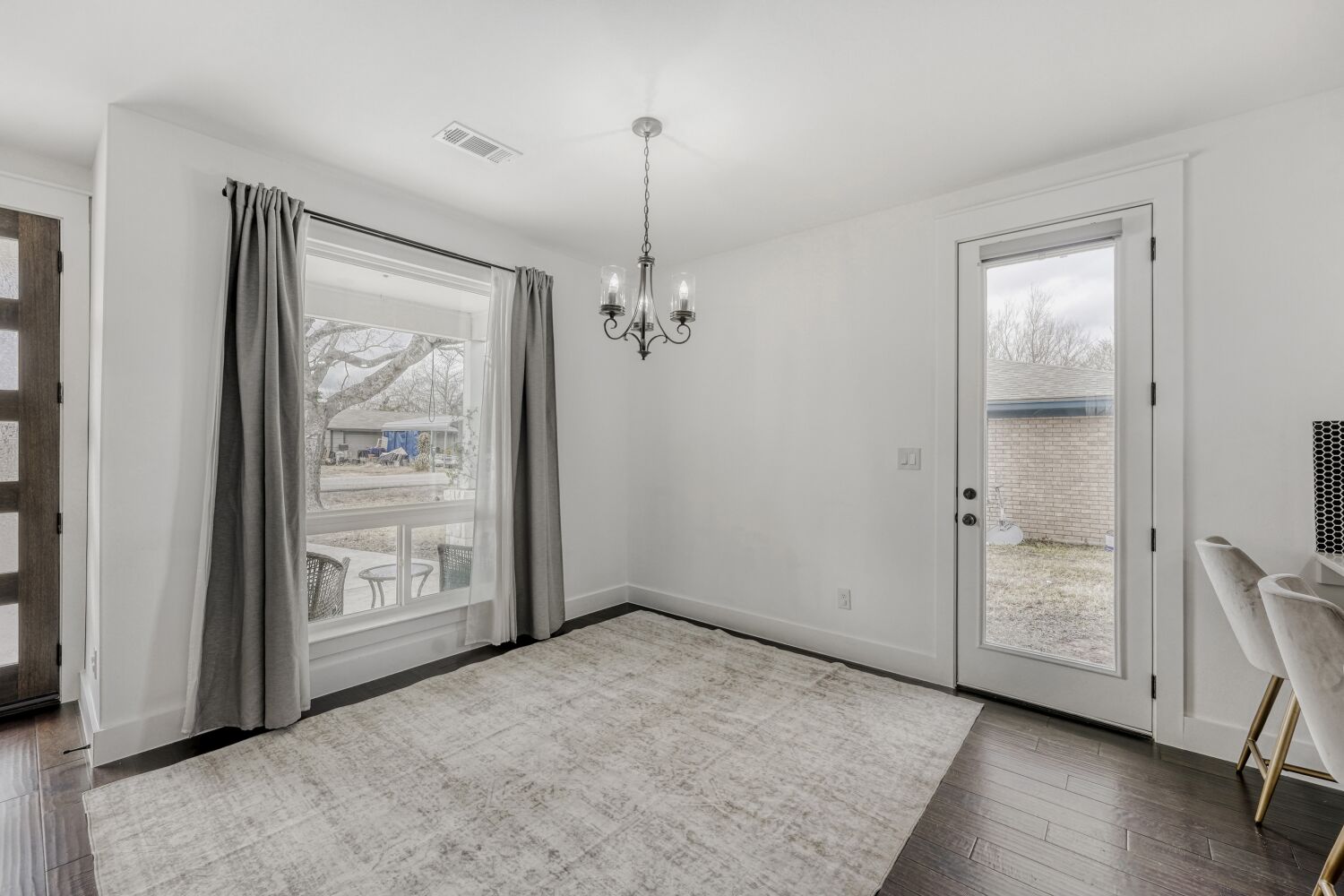 125 Irene Street Elgin, TX 78621 - Photo 5 of 24 Unfurnished dining area with suspended lighting, dark wood-style flooring, and healthy amount of natural light