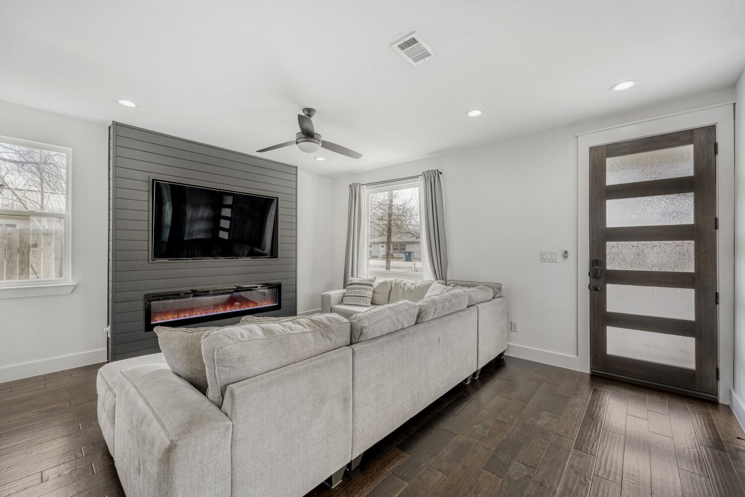 125 Irene Street Elgin, TX 78621 - Photo 6 of 24 Living room with dark wood-style floors, a ceiling fan, a large fireplace, and recessed lighting