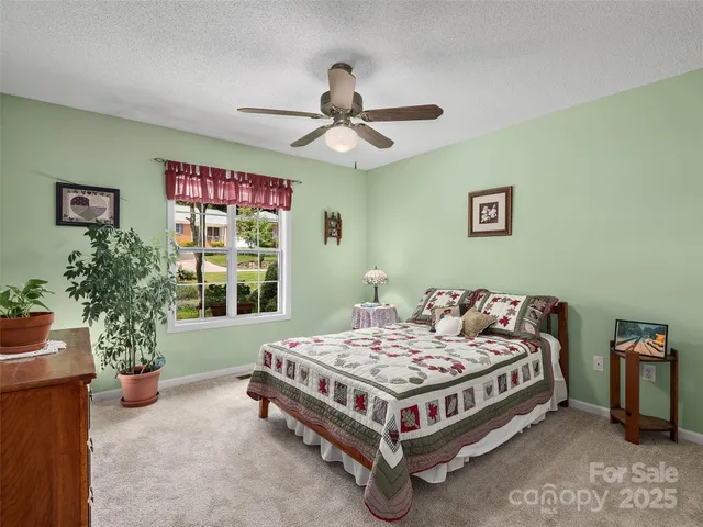 a bed sitting in a bedroom next to a window