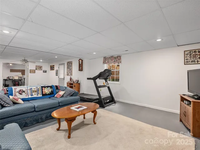 a living room with furniture a flat screen tv and a rug