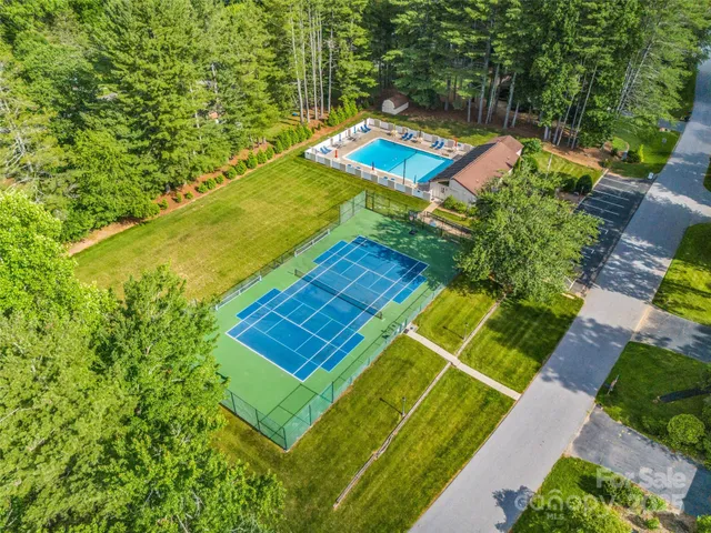 a view of a tennis ground with large trees