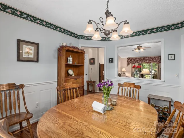 a view of a dining room with furniture a chandelier and wooden floor