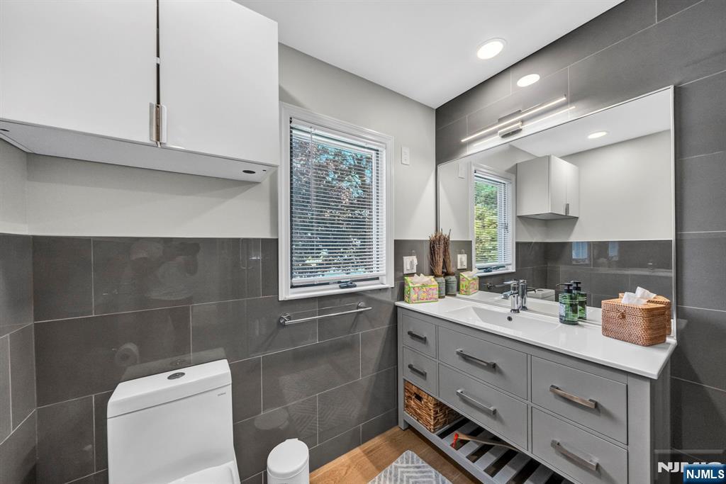 57 Hemlock Road Little Falls, NJ 07424 - Photo 20 of 50 a bathroom with a double vanity sink toilet and mirror