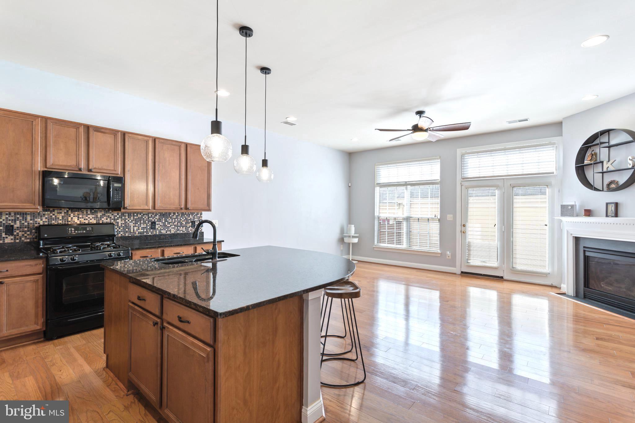 9152 Ribbon Falls Loop Bristow, VA 20136 - Photo 15 of 61 a kitchen with stainless steel appliances granite countertop a stove a sink and a refrigerator