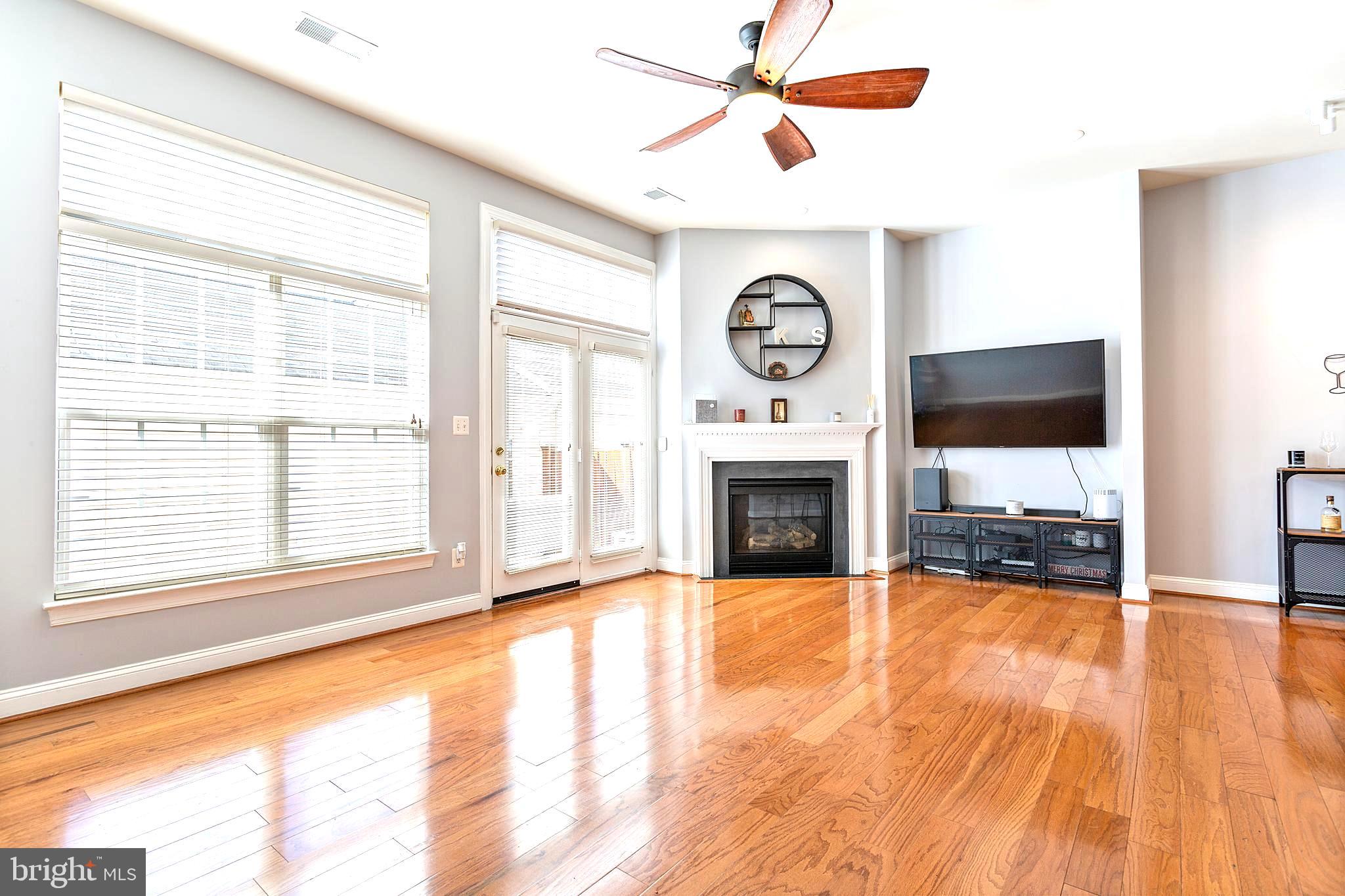 9152 Ribbon Falls Loop Bristow, VA 20136 - Photo 19 of 61 a view of a livingroom with a fireplace a ceiling fan and a window