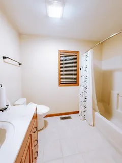 a view of an empty room with a chandelier fan