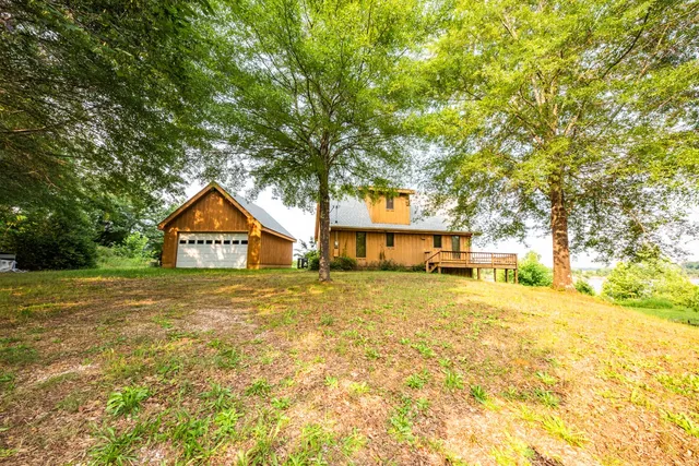 an aerial view of a house with swimming pool next to a yard