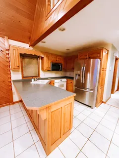a open kitchen with a sink and refrigerator