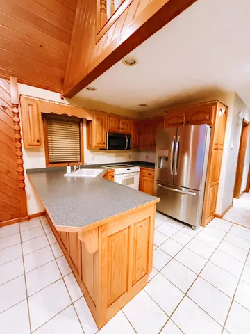 a open kitchen with a sink and refrigerator