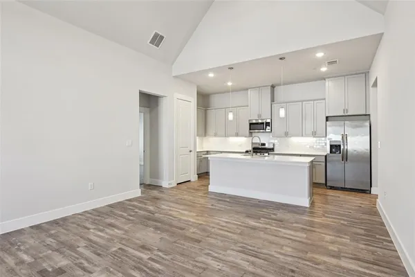 a kitchen with white cabinets and appliances