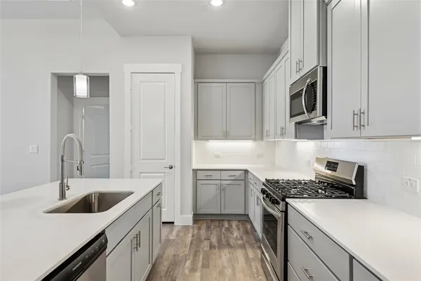 a kitchen with stainless steel appliances granite countertop a sink stove and refrigerator