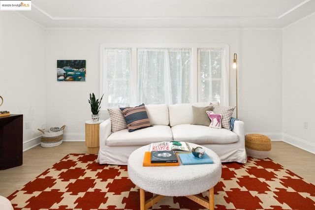 a living room with furniture a rug and wall paintings