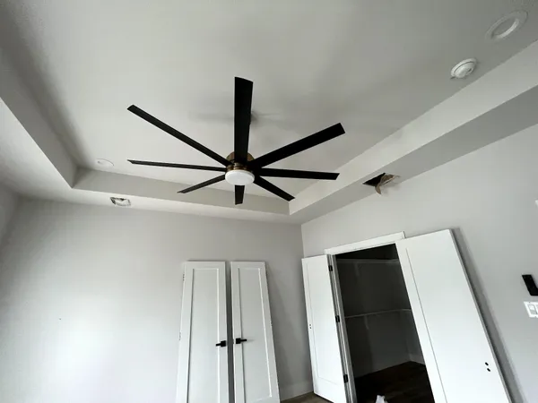 a view of a hallway with a ceiling fan