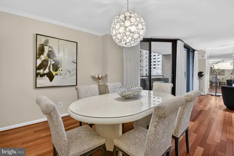 a view of a dining room with furniture a chandelier and wooden floor