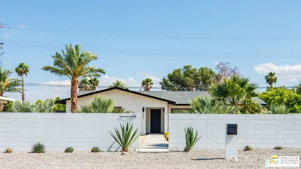 a view of a house with a yard and potted plants