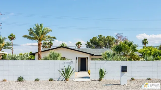 a view of a house with a yard and potted plants
