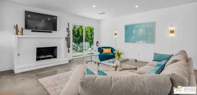 a living room with furniture a fireplace and a flat screen tv