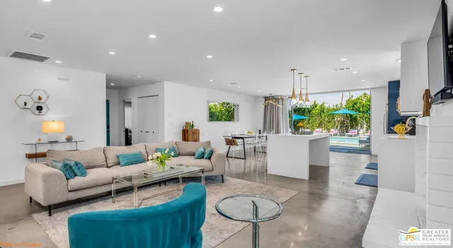 a bedroom with a bed couches and a flat tv screen