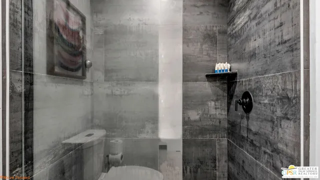 a bedroom with a bed painting on wall and a large window