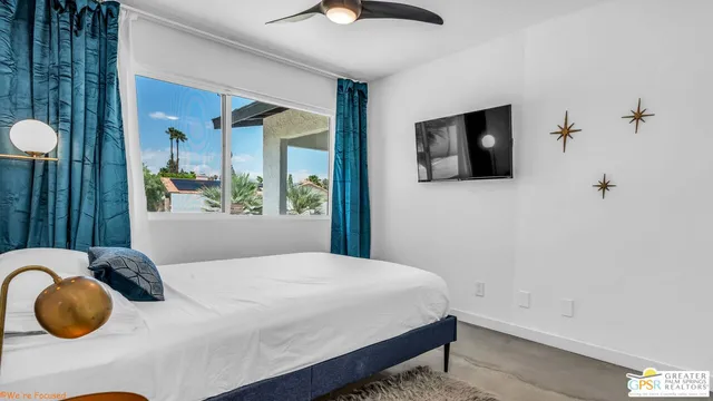 a bedroom with a bed and painting on the wall