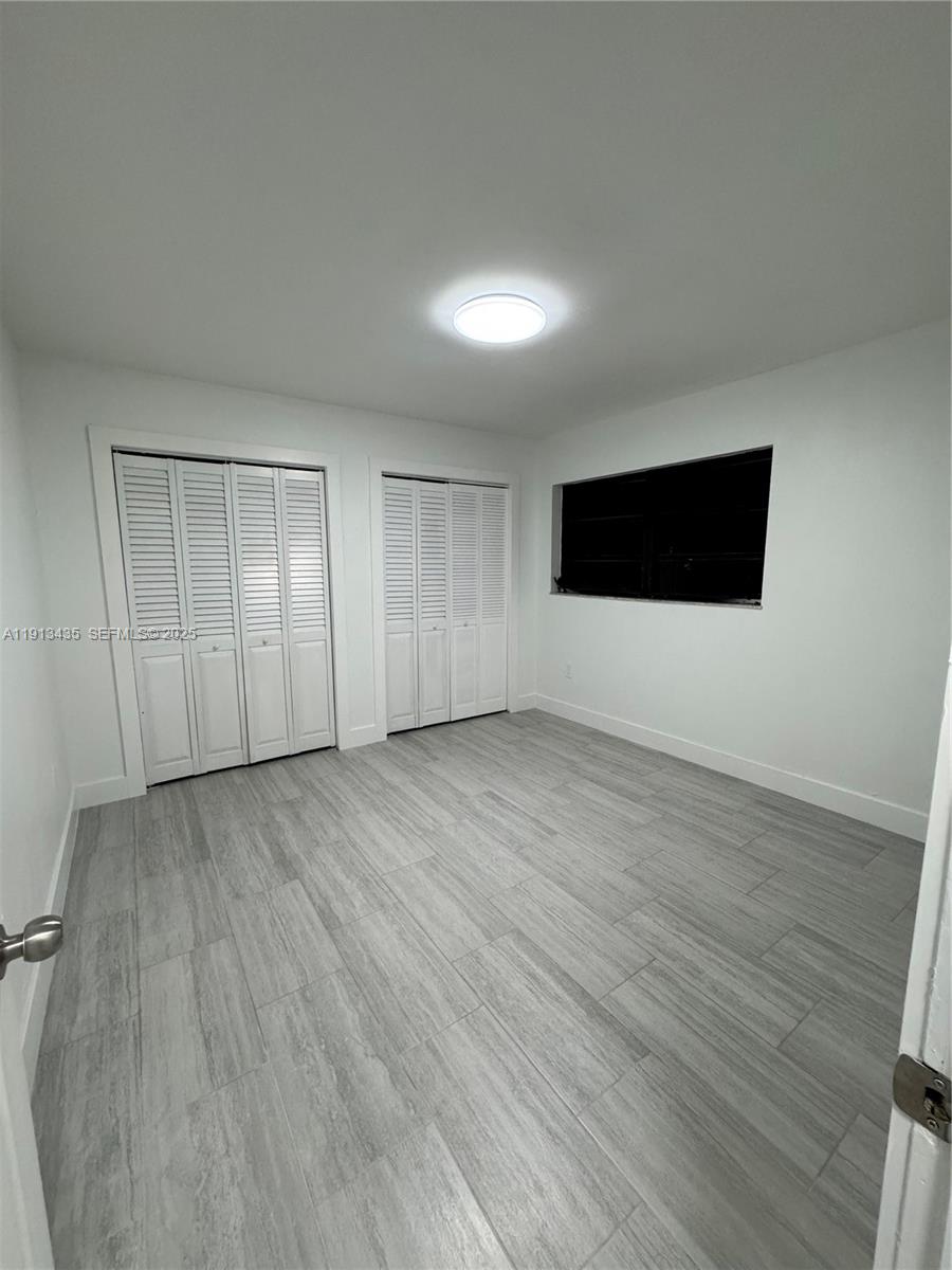 1799 Southwest 36th Avenue, Unit 1 Miami, FL 33145 - Photo 11 of 14 a view of an empty room with wooden floor