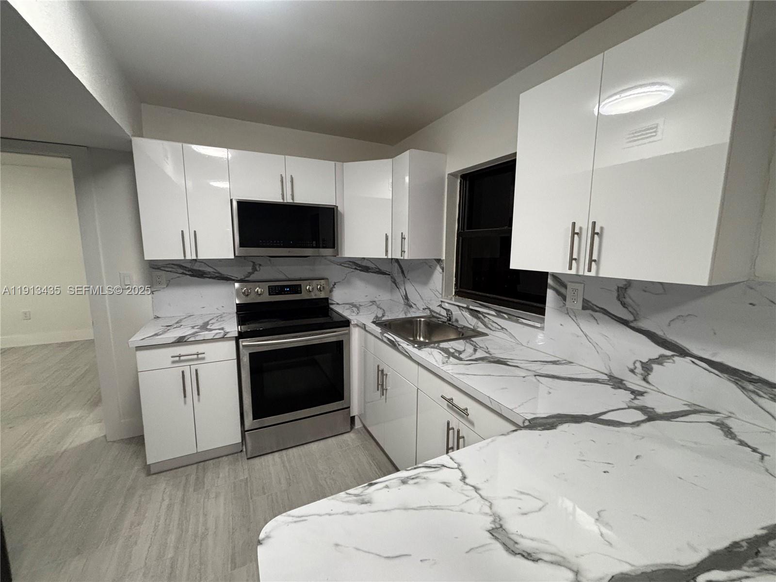 1799 Southwest 36th Avenue, Unit 1 Miami, FL 33145 - Photo 3 of 14 a kitchen with a stove and a microwave