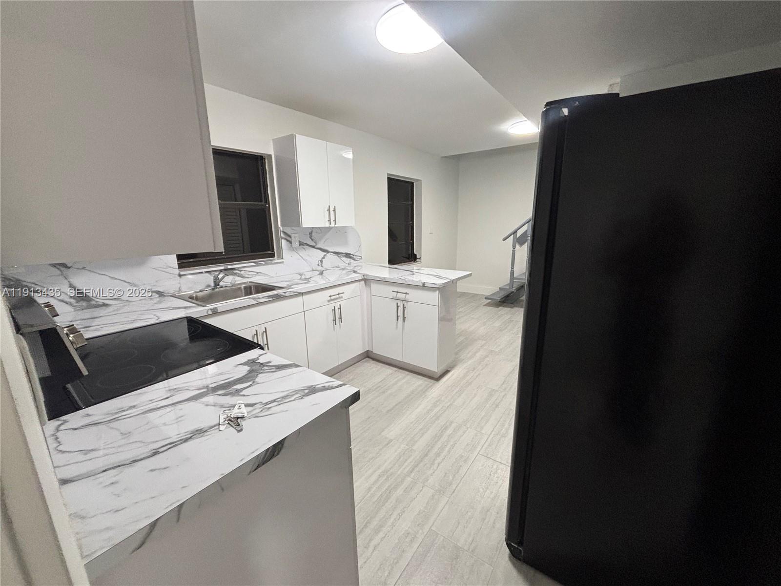 1799 Southwest 36th Avenue, Unit 1 Miami, FL 33145 - Photo 5 of 14 a kitchen that has a sink and a stove in it