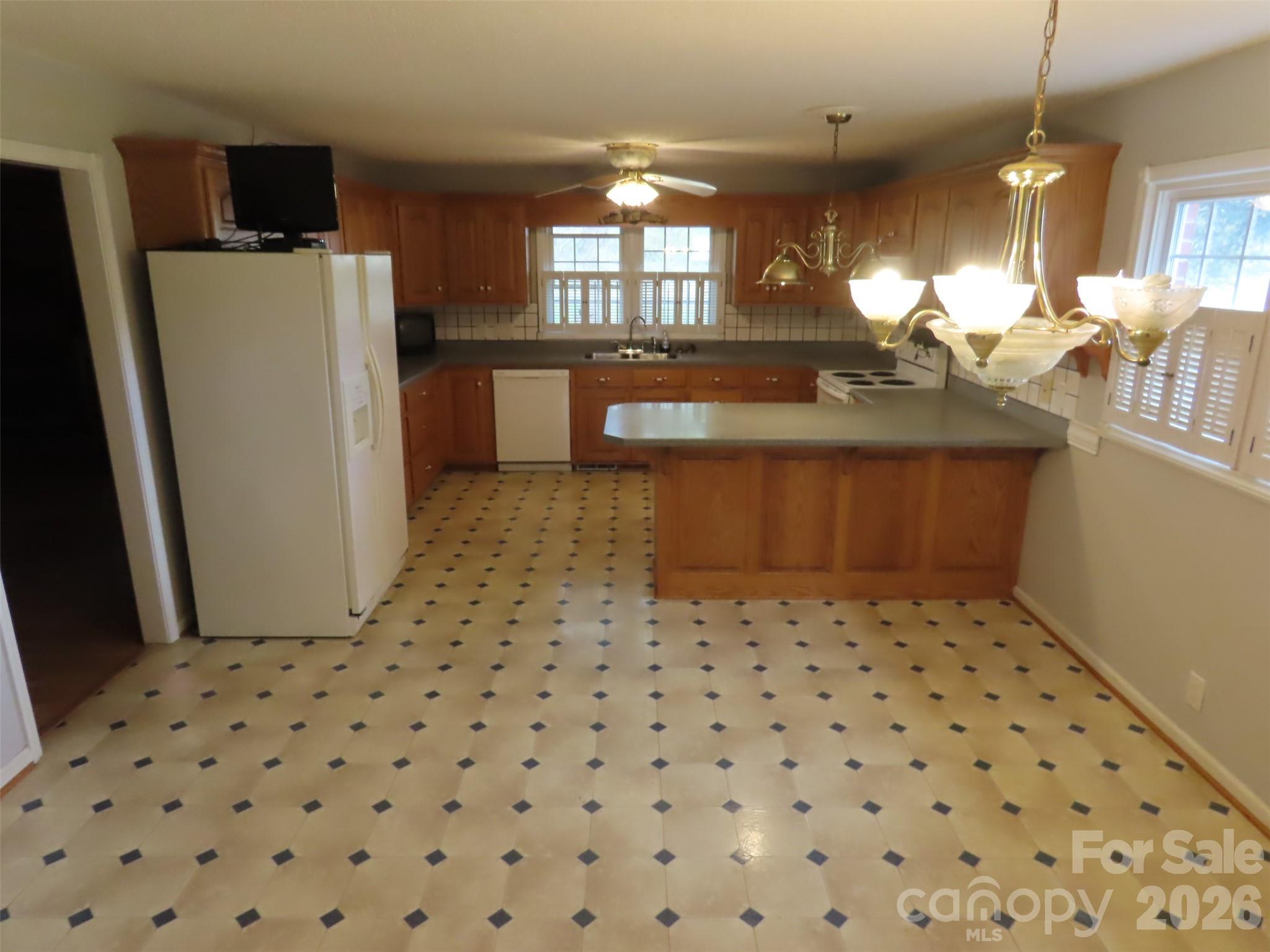 2724 Lucy Short Cut Road Marshville, NC 28103 - Photo 11 of 28 a kitchen with a sink a refrigerator and cabinets
