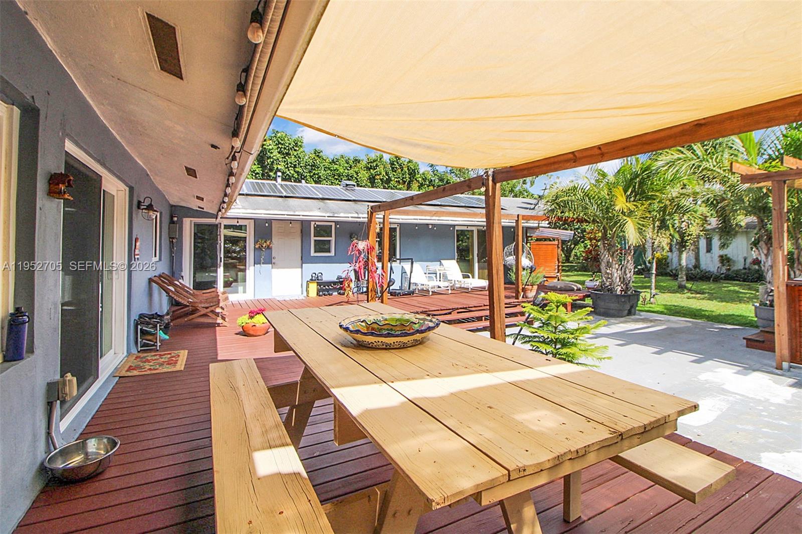 37225 Southwest 214th Avenue Homestead, FL 33034 - Photo 28 of 77 a view of a patio with table and chairs potted plants with wooden floor