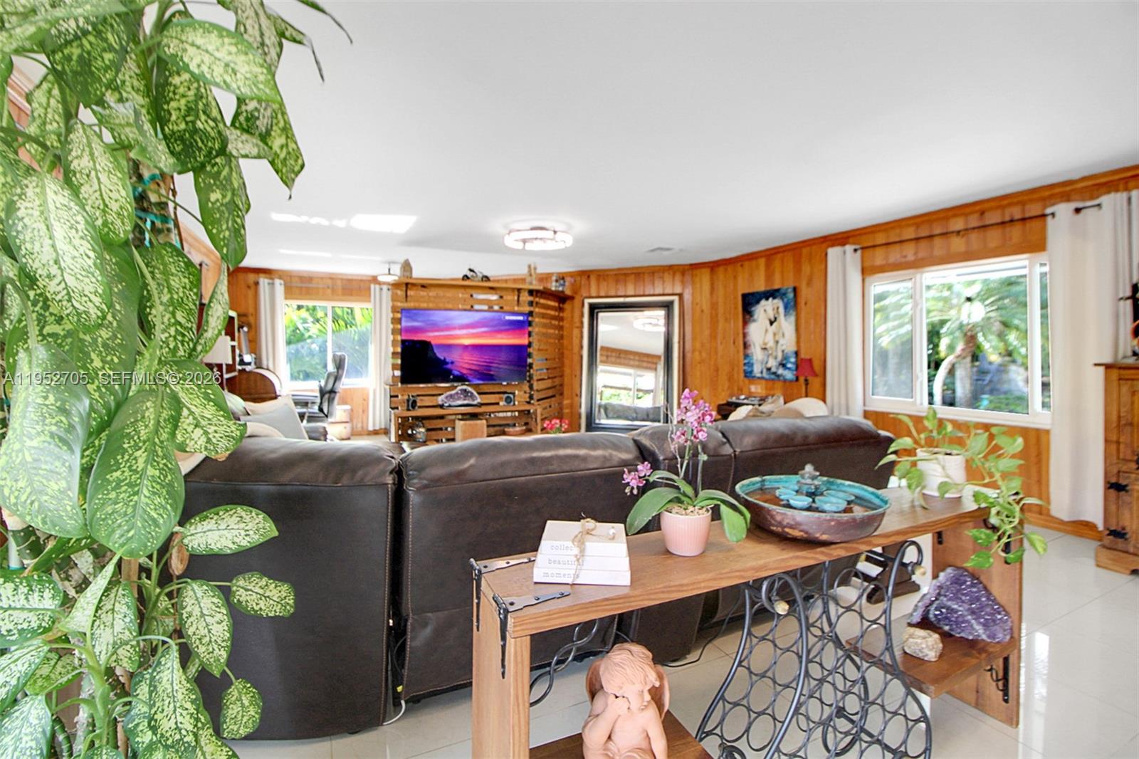 37225 Southwest 214th Avenue Homestead, FL 33034 - Photo 53 of 77 a living room with furniture a flat screen tv and a floor to ceiling window