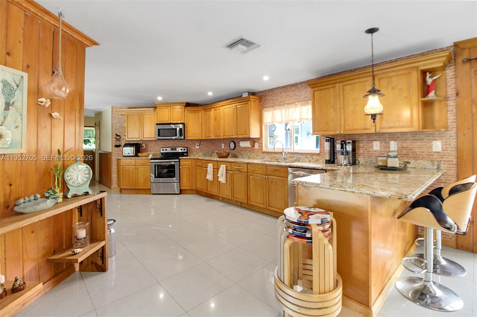 37225 Southwest 214th Avenue Homestead, FL 33034 - Photo 55 of 77 a kitchen with stainless steel appliances kitchen island granite countertop a sink and cabinets