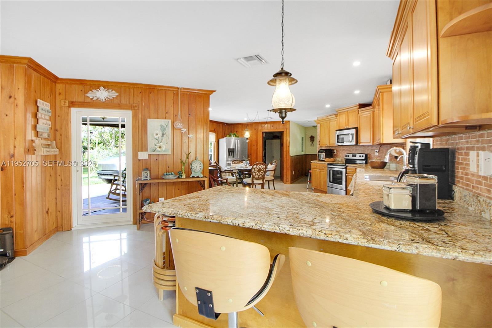 37225 Southwest 214th Avenue Homestead, FL 33034 - Photo 56 of 77 a kitchen with stainless steel appliances granite countertop a sink counter space and a view of living room