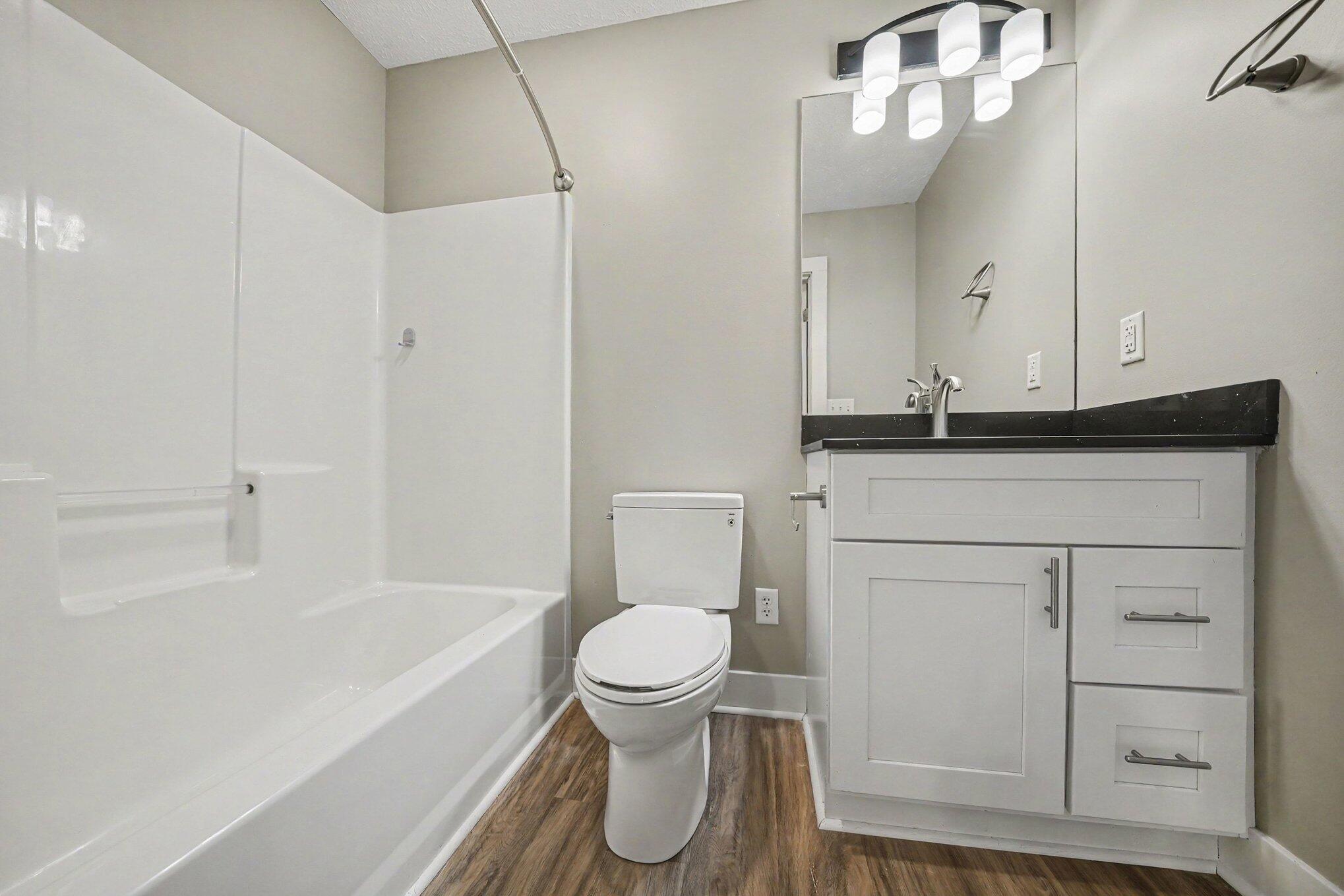 7563 East 400 North Rolling Prairie, IN 46371 - Photo 8 of 17 a bathroom with a granite countertop toilet sink and mirror